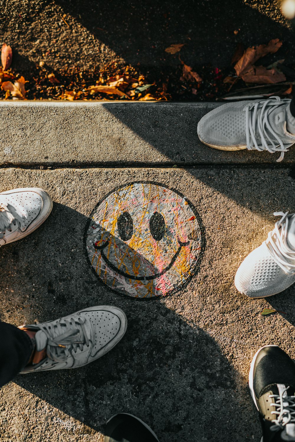 smiley paint on gray ground in front of people