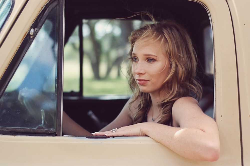 woman driving on beige vehicle