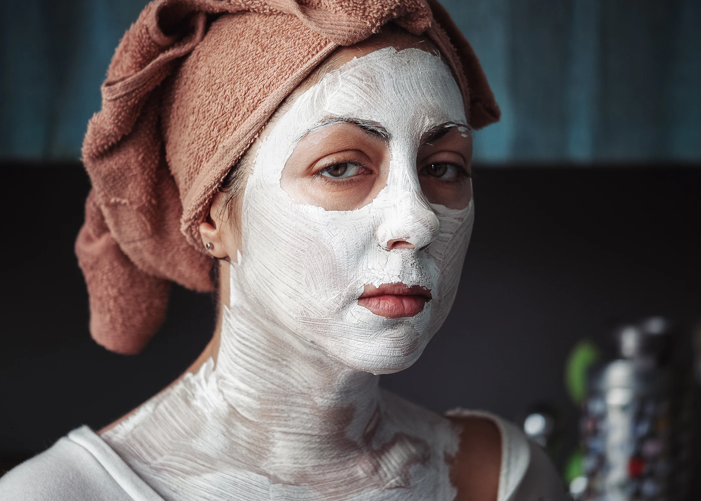 Shallow-focus portrait of a woman having a facial treatment, representing the hands-on extraction step of an Acne Care Facial session