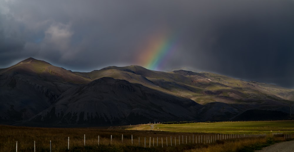 photo of green mountains and rainbow