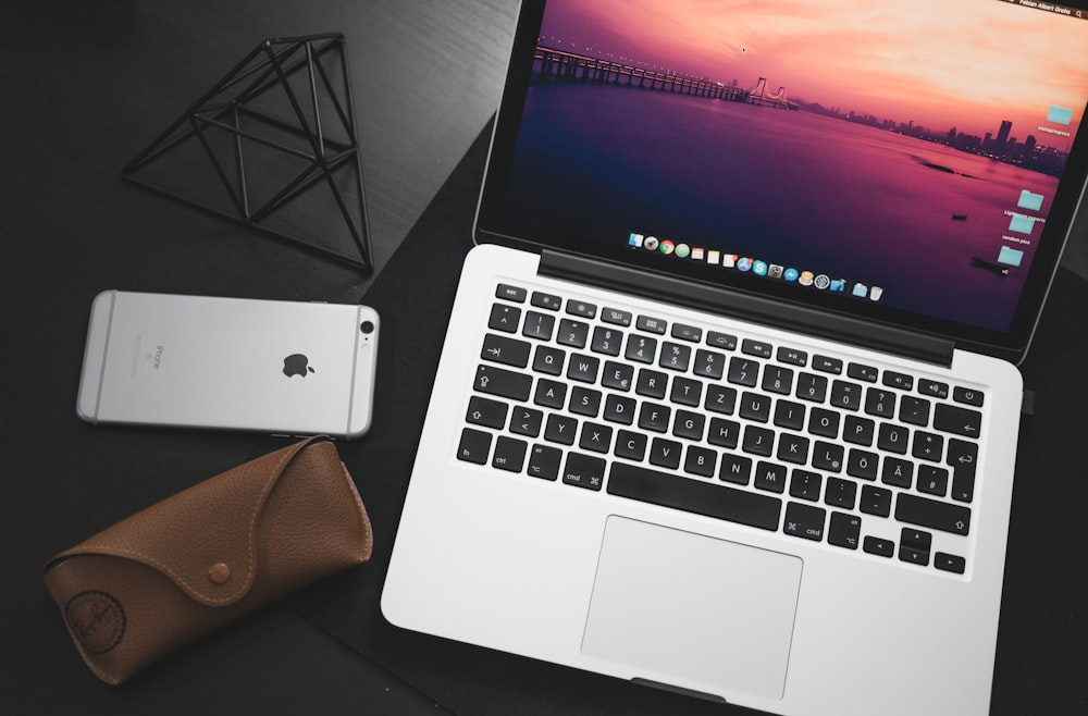 MacBook Pro al lado del espacio iPhone 6 sobre superficie de madera negra