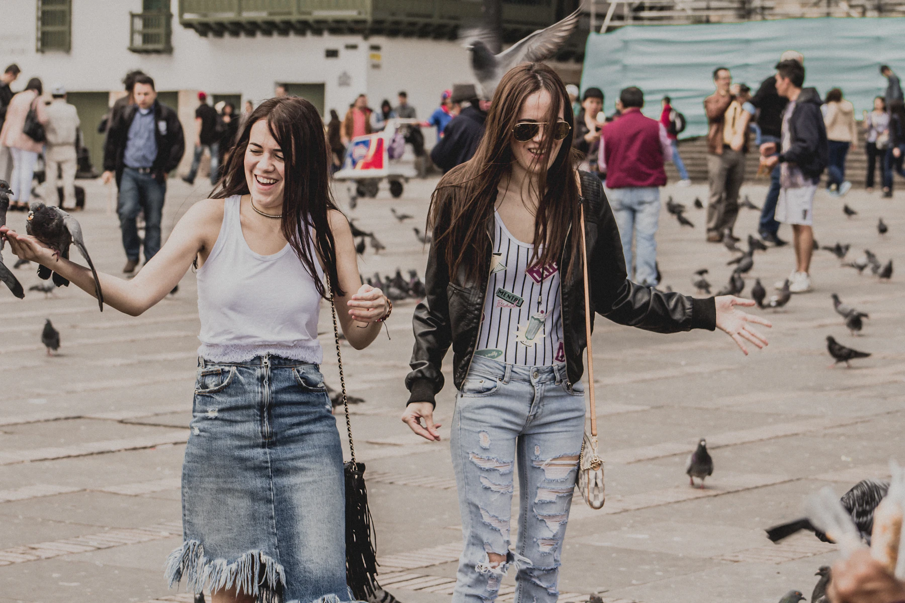 Dos mujeres junto a palomas en una plaza de Bogotá