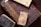 A collection of old, ornate books with richly carved and aged leather covers, featuring intricate designs and embossments. The books are stacked on a wooden surface, displaying their worn and historic appearance.