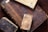 A collection of old, ornate books with richly carved and aged leather covers, featuring intricate designs and embossments. The books are stacked on a wooden surface, displaying their worn and historic appearance.