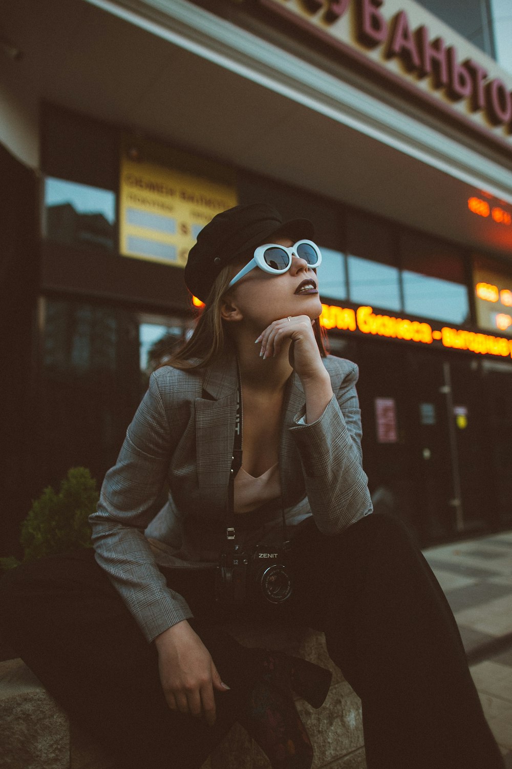 Mujer con gafas de sol y sentada en la roca