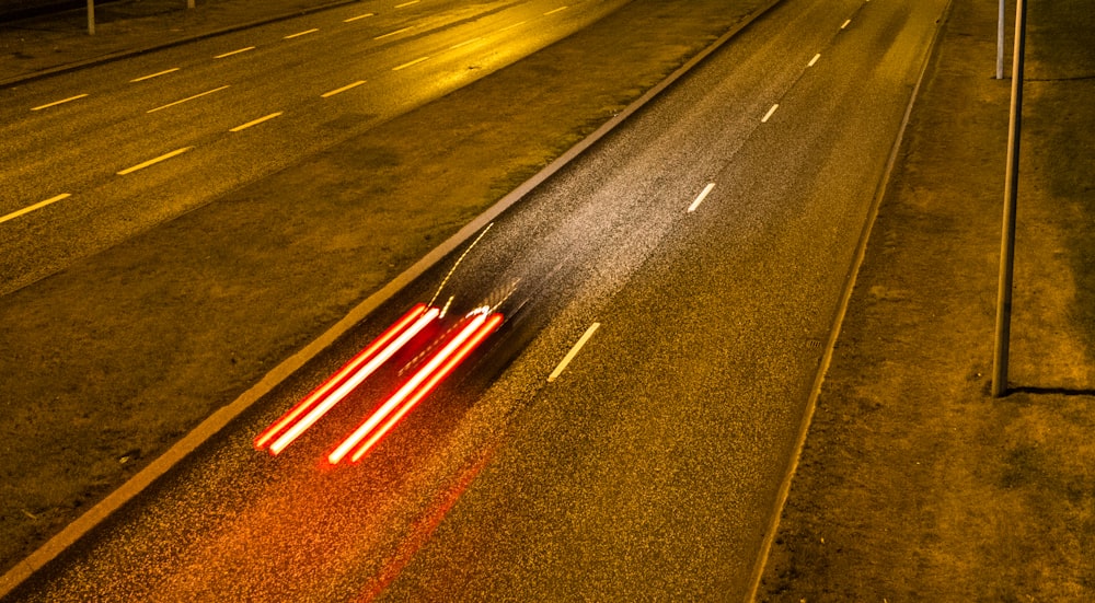 panning photo of vehicle traveling on concrete road