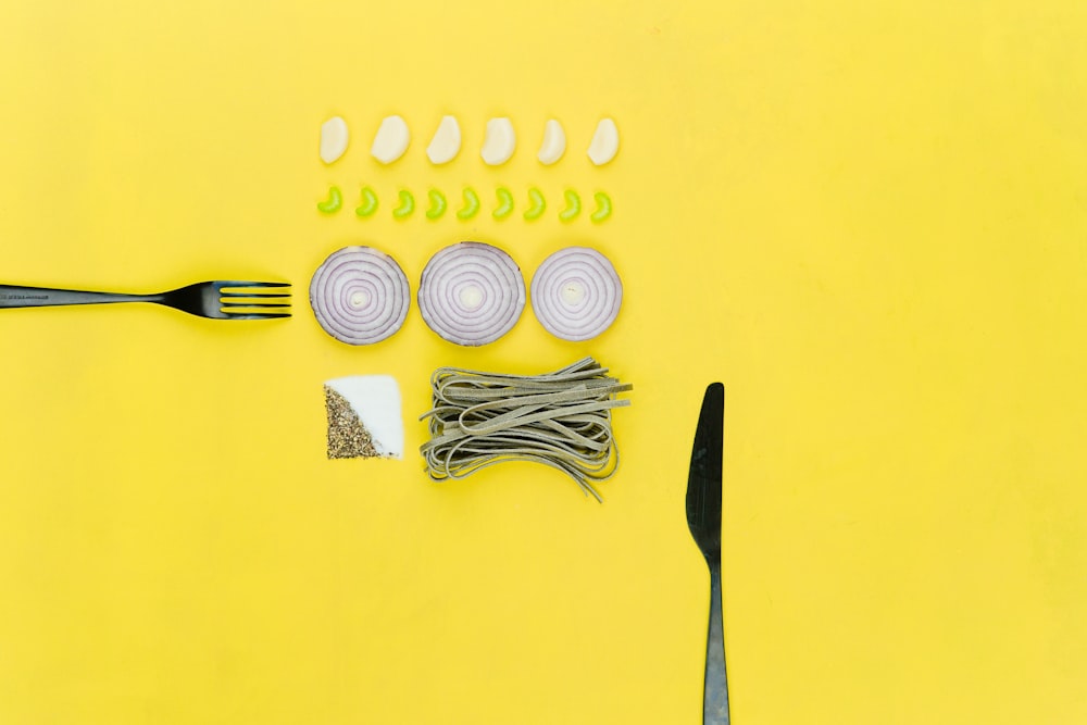 bread knife and sliced onion on yellow table