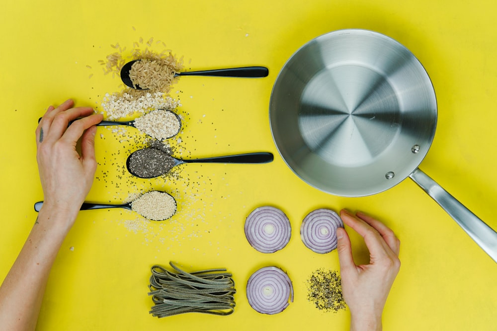 flat lay photography of saute skillet beside spoon of spices and vegetables