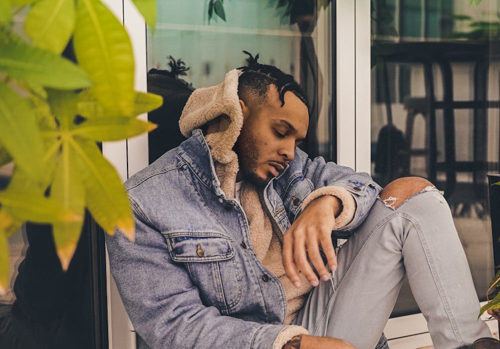 man sitting leaning on door glass