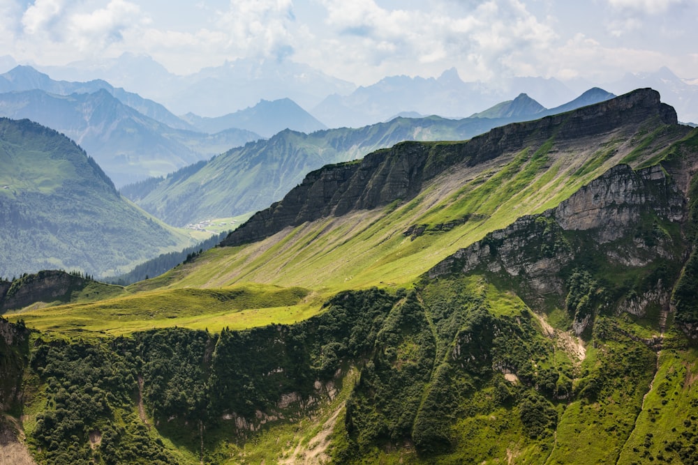 a scenic view of a mountain range with green mountains in the background