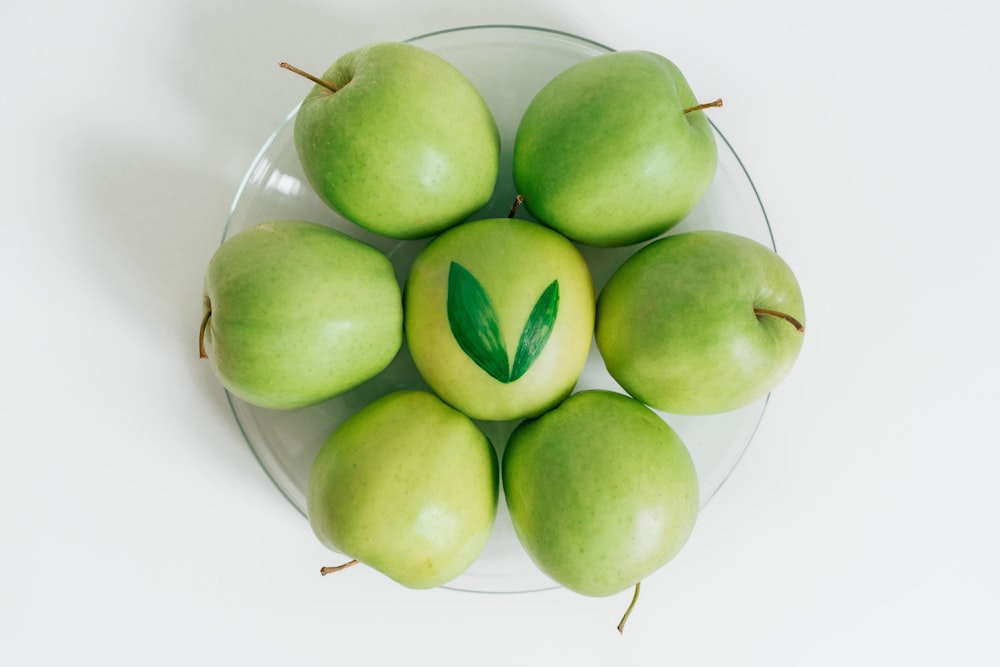 seven green apples served on bowl