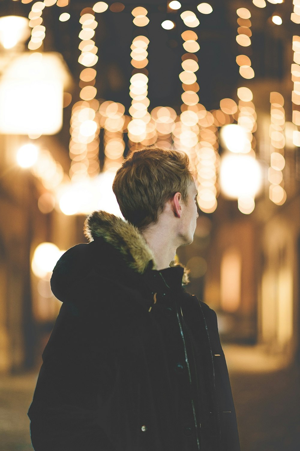 Fotografia Bokeh do homem na jaqueta preta do Parka