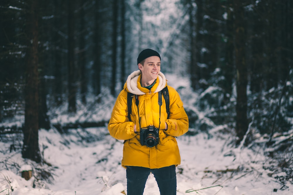 person standing on snow in between trees