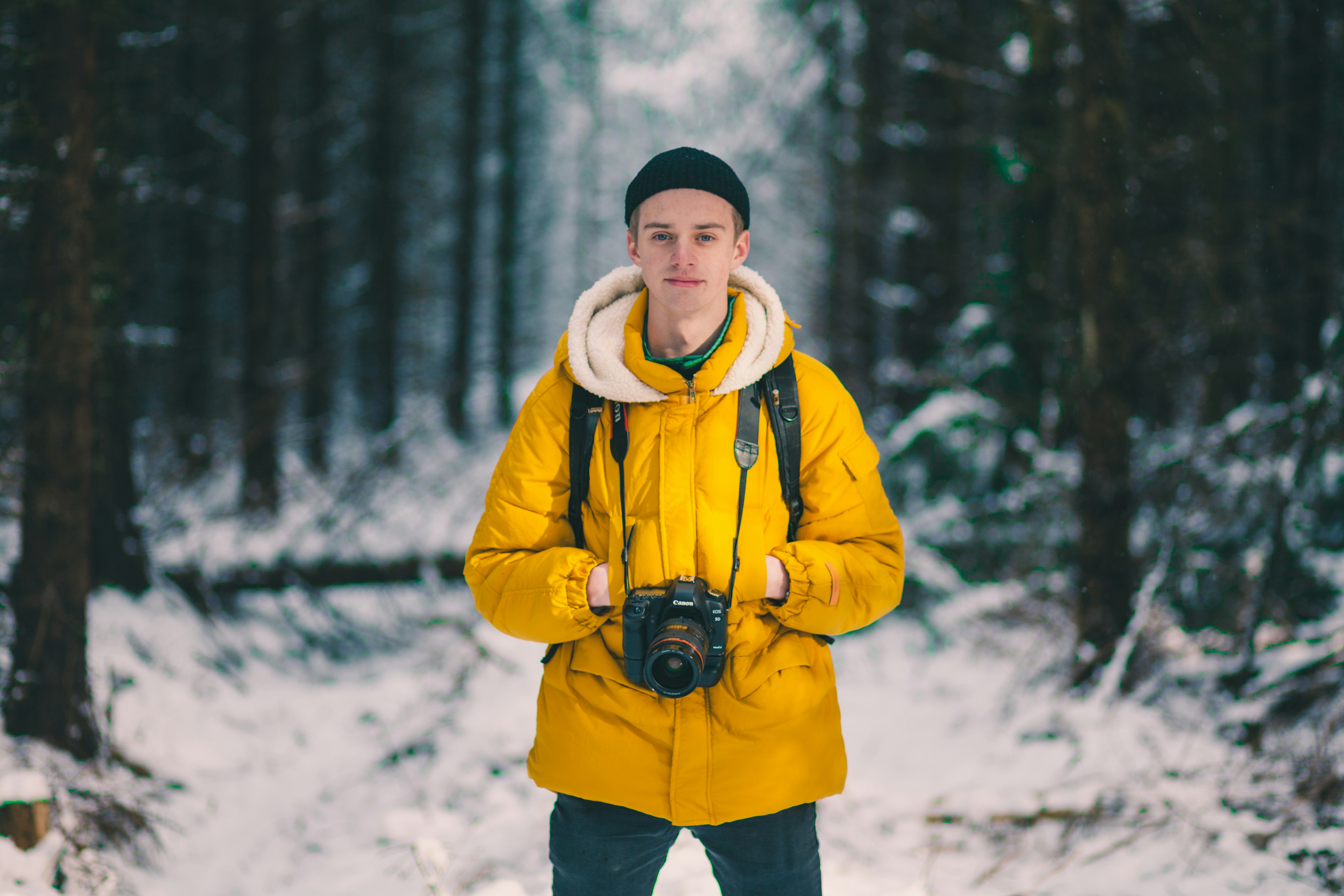 selective focus photo of man standing holding DSLR camera