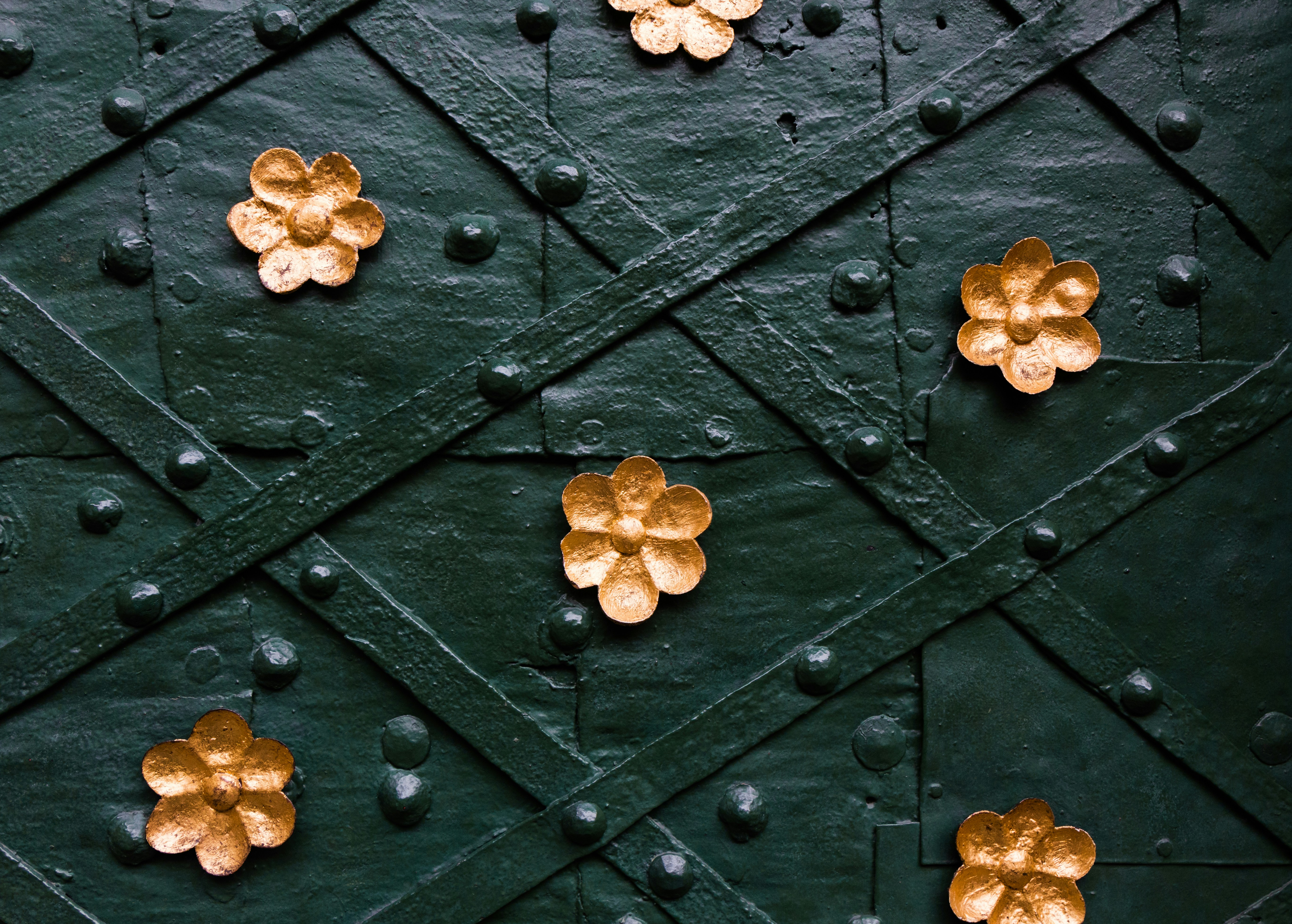 a close up of a wall with gold flowers on it