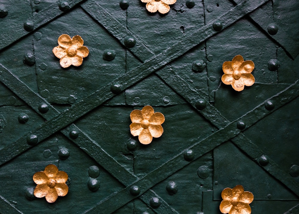 a close up of a wall with gold flowers on it