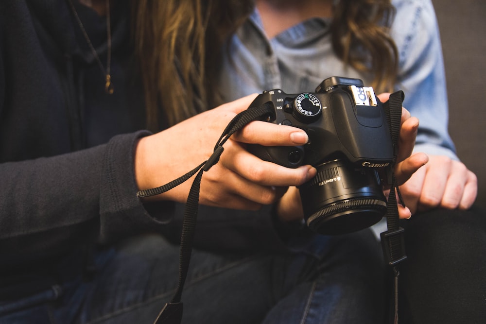 woman holding Canon DSRL camera