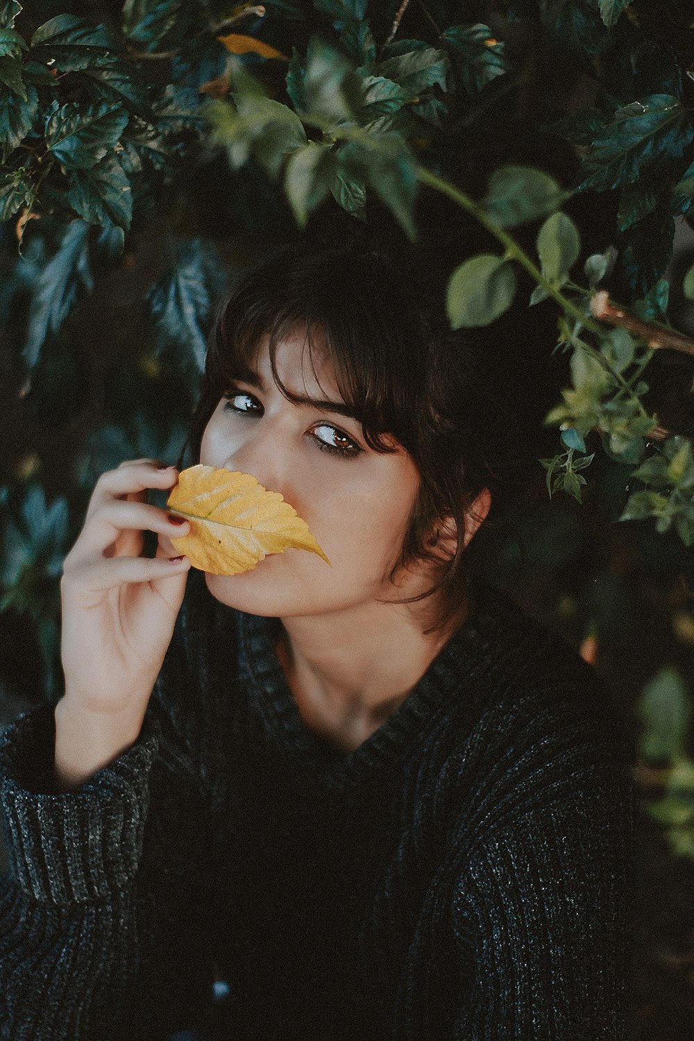 woman smelling brown leaf