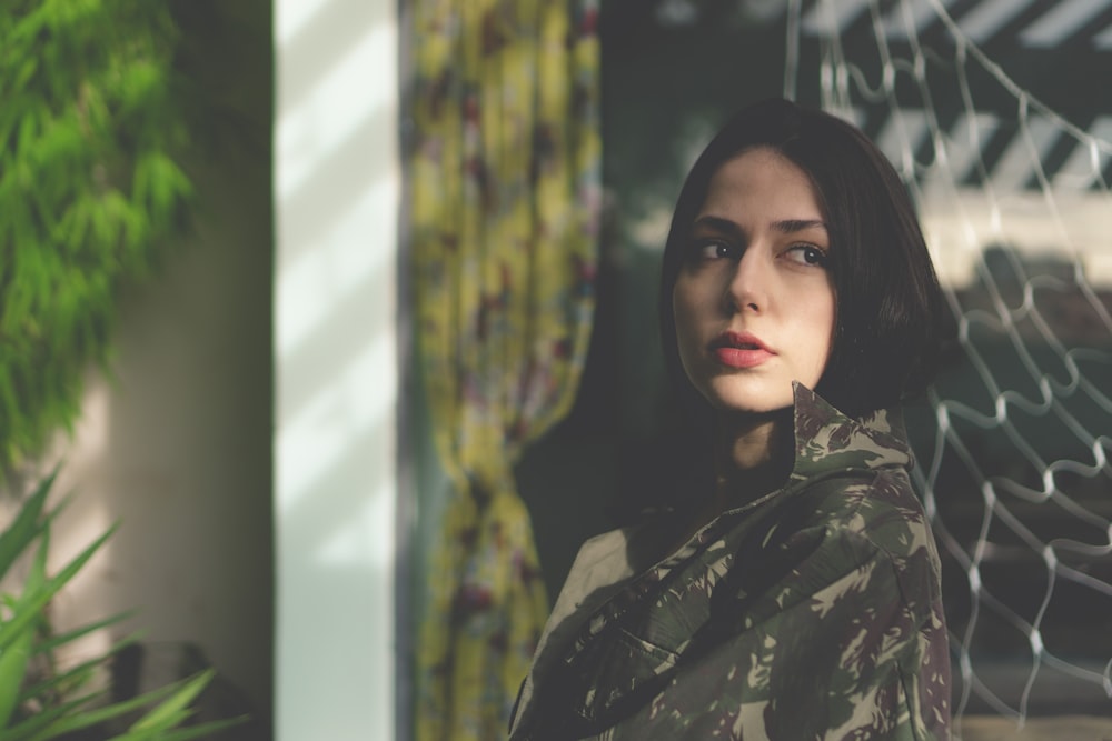 woman in woodland camouflage top leaning on fence