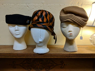 Leather beret displayed on a vintage mannequin head against a neutral backdrop.