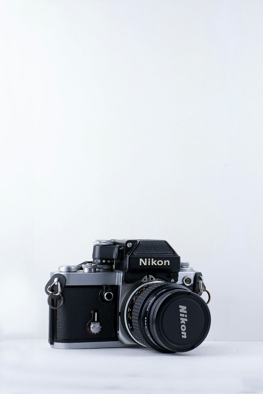 cámara Nikon negra sobre fondo blanco