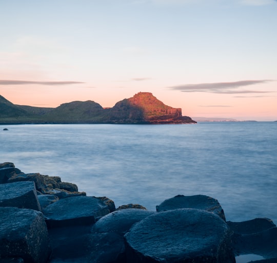 mountain cliff beside sea during daytime in Giant's Causeway United Kingdom