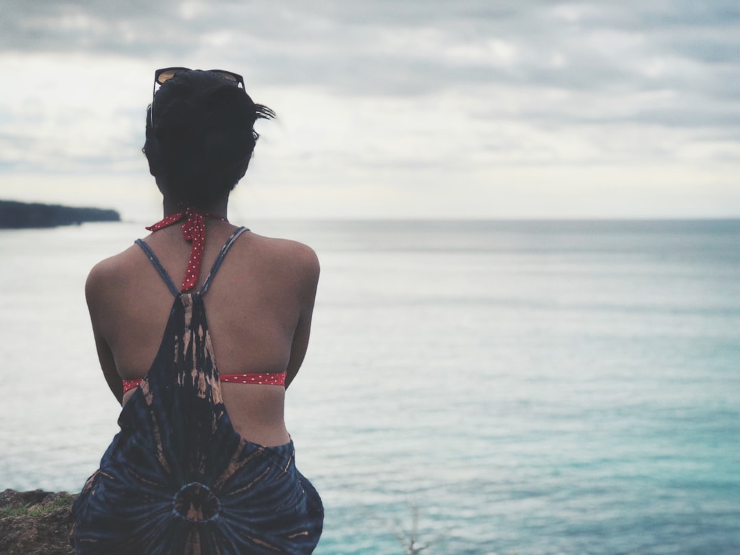 woman sitting near body of water