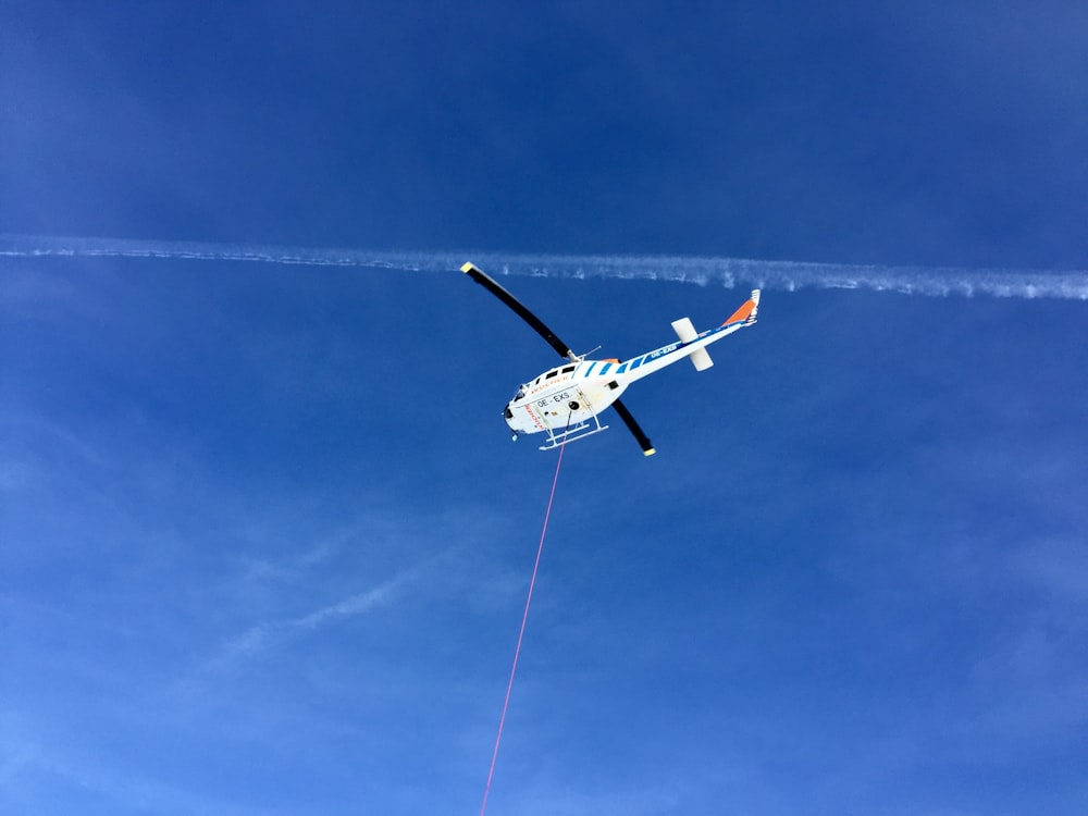 worm's-eye view of helicopter under cloudy sky