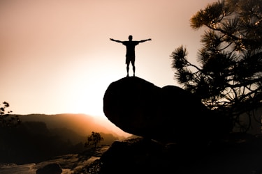silhouette of person on rock