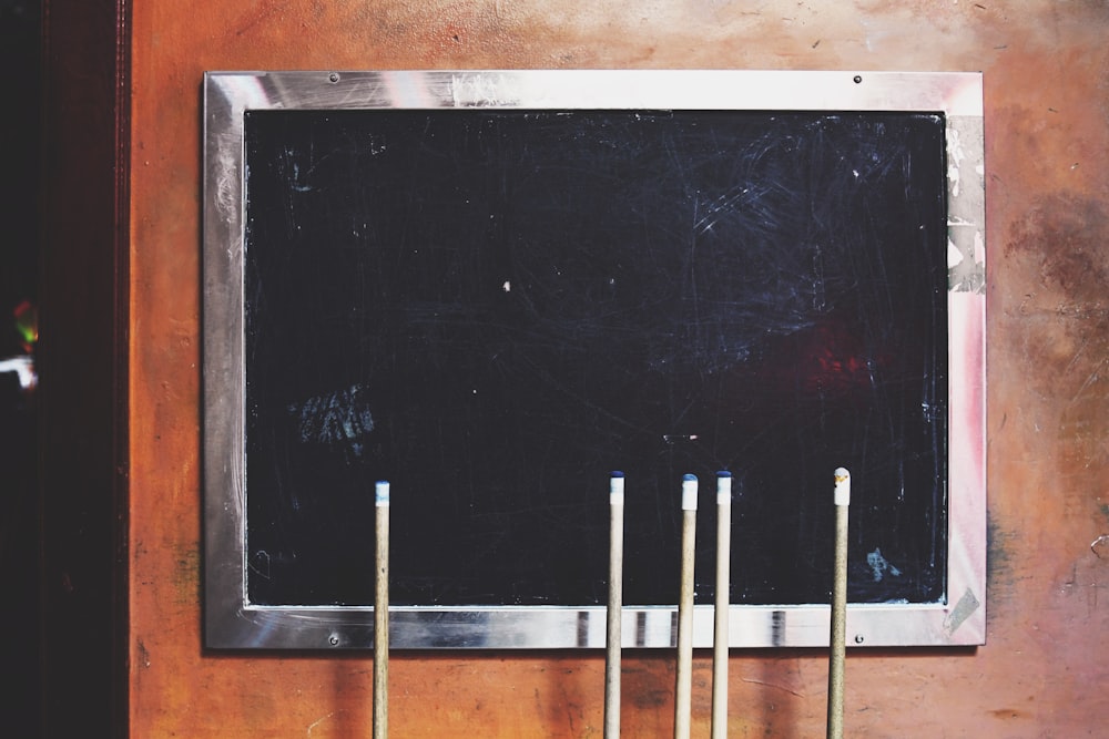 a chalkboard mounted to a wall with four candles