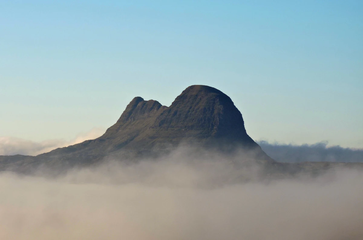 The rounded summit of Suilven standing above a layer of low mist