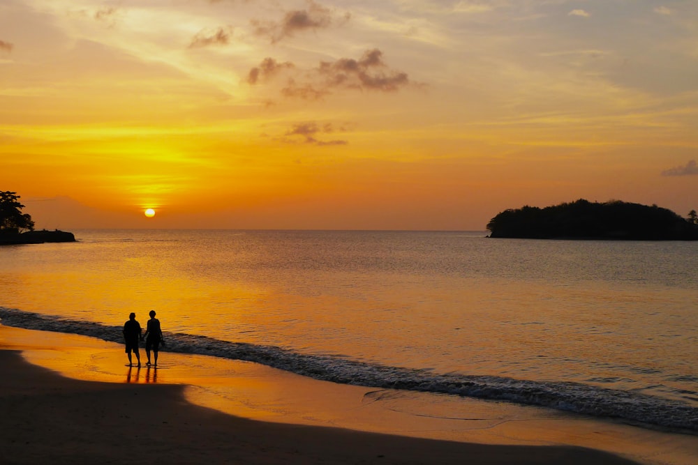 two person on beach during sunset