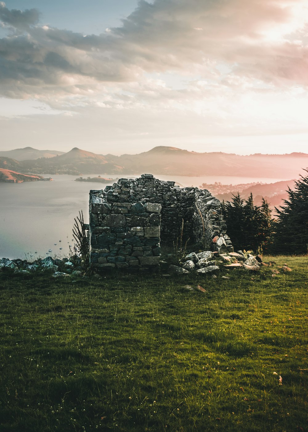 a stone structure sitting on top of a lush green field