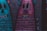 A vibrant graffiti artwork on a brick wall featuring cartoonish figures with exaggerated facial features. The designs are colorful and incorporate various patterns, with elements like big eyes, large teeth, and whimsical facial expressions.