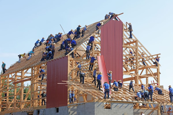 a large number of workers constructing the wooden structure of a building