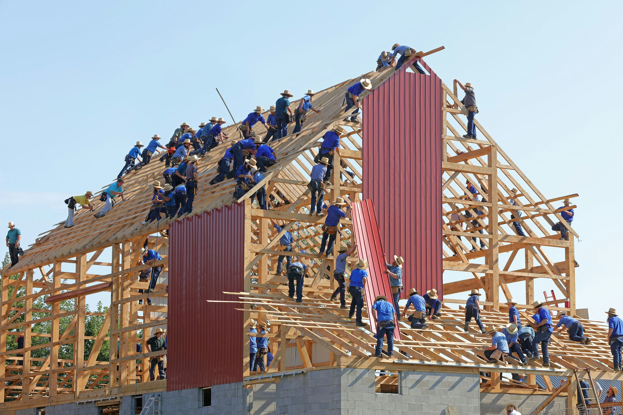 a large number of workers constructing the wooden structure of a building