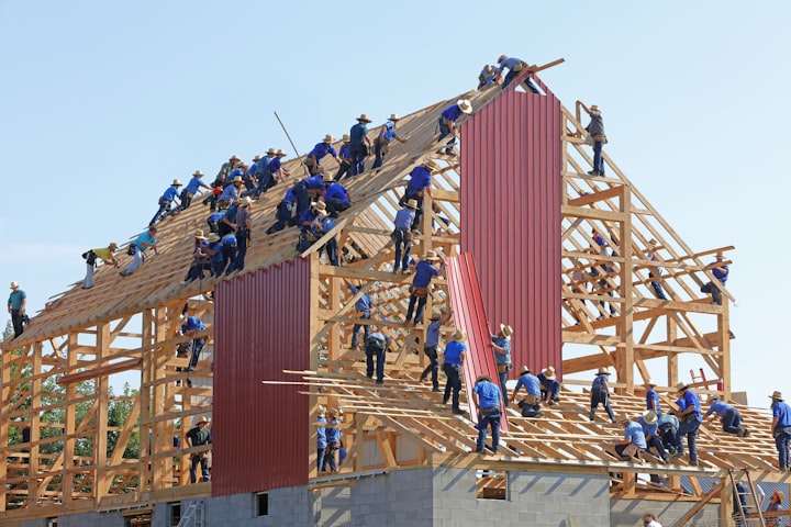 Lots of people building the roof of a large building