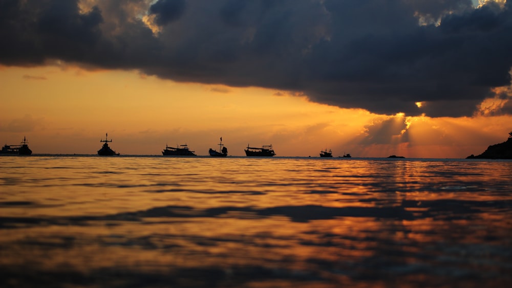 landscape photography of group of ships under golden hour