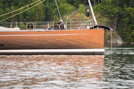 Close-up of a freshly polished boat hull reflecting the water's surface.
