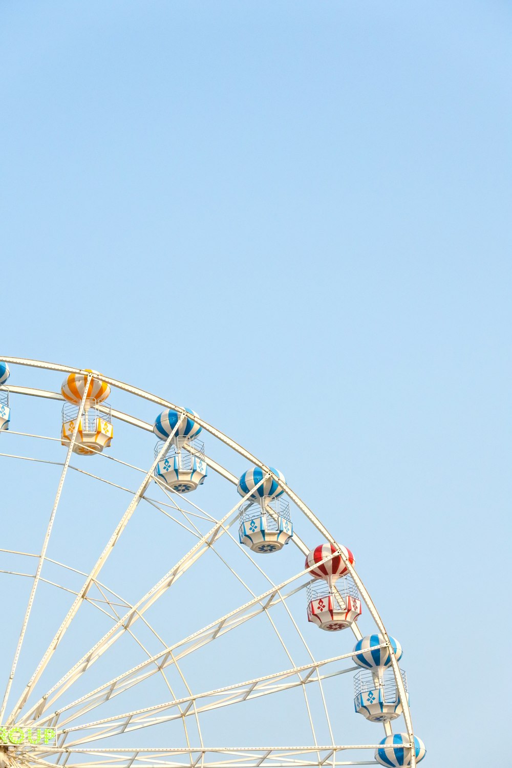 Blick aus der Wurmperspektive auf das Riesenrad unter strahlend blauem Himmel