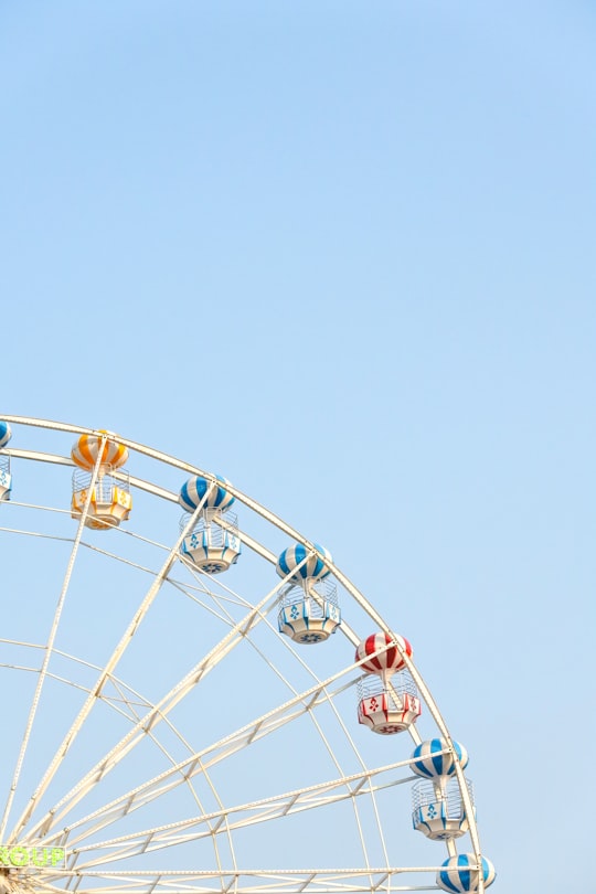 worm's eye view of Ferris Wheel under clear blue sky in Phetchabun Thailand