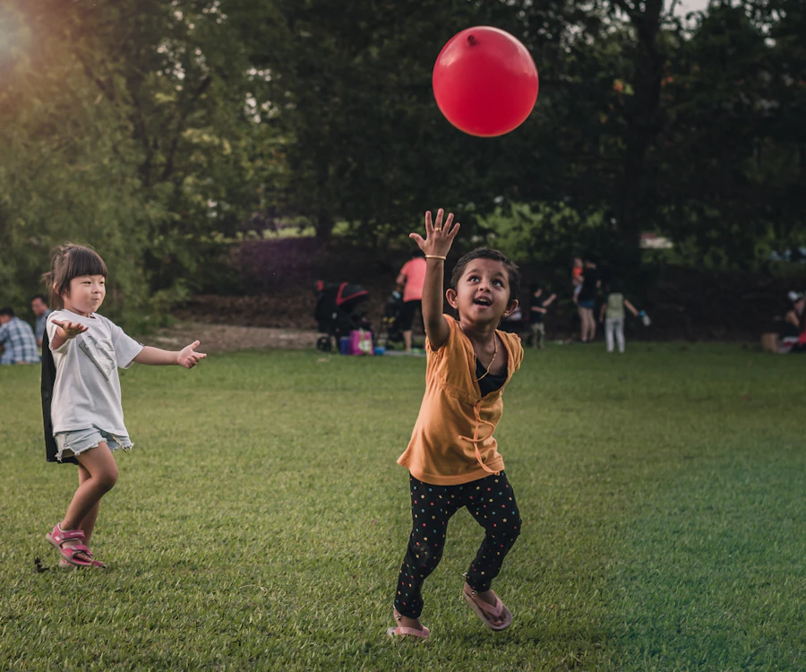 Children laughing and playing with balloons outdoors