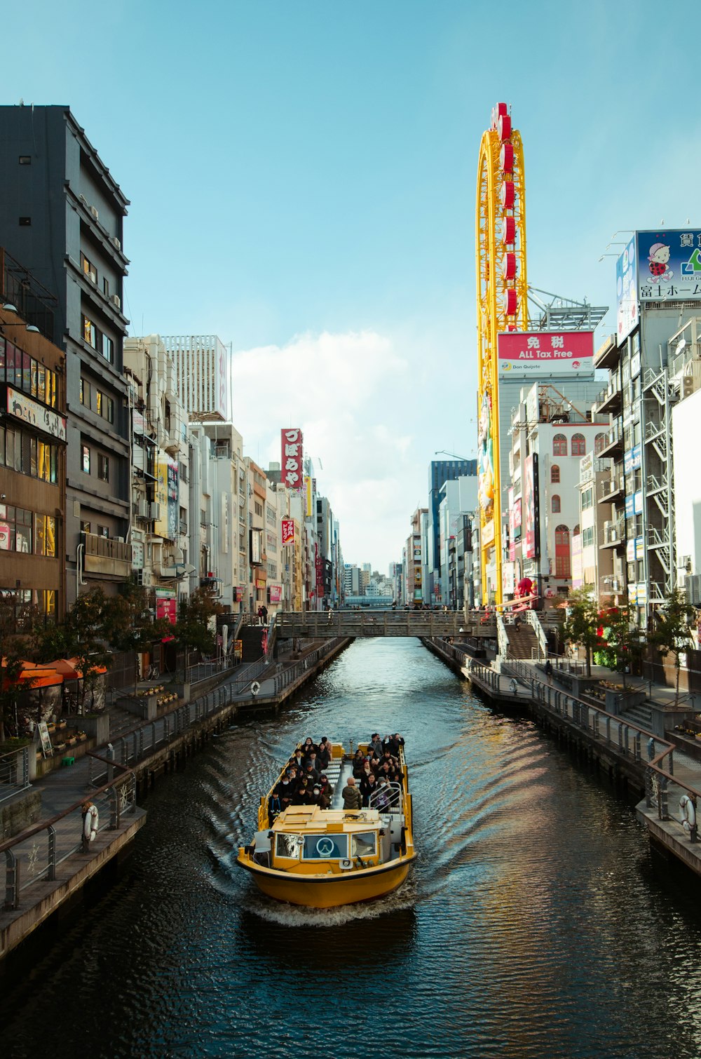 yellow boat in canal between buildings during daytime