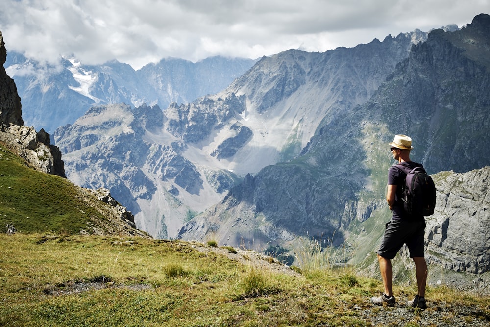 photo of man standing near mountains