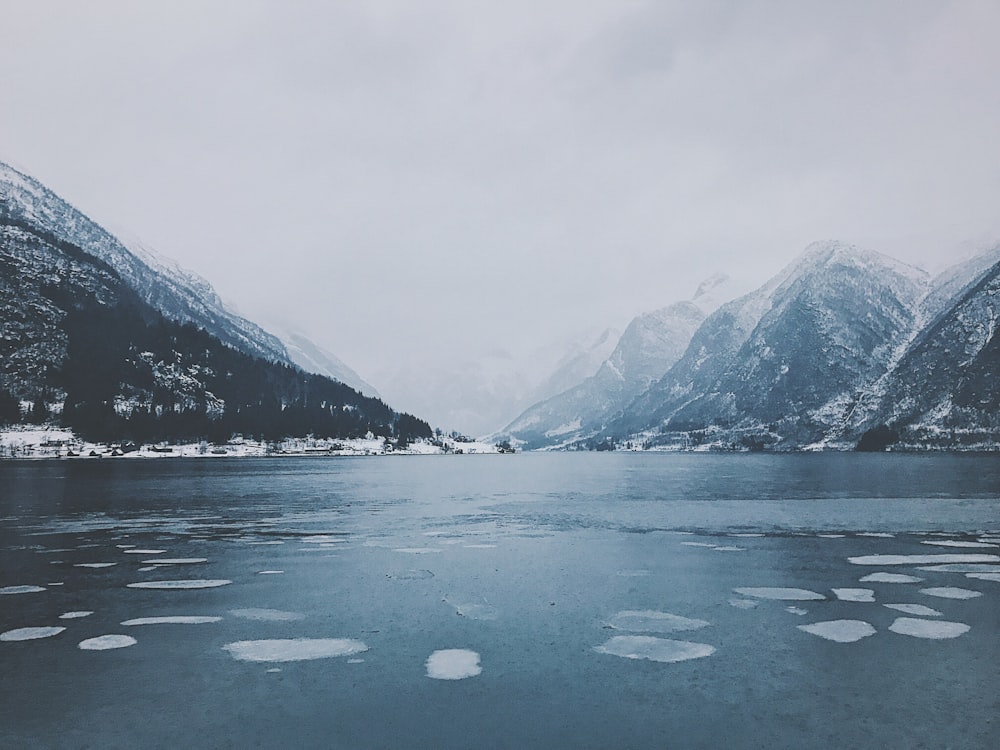 body of water surrounded by snowy mountain