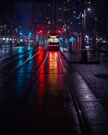 photo of tram beside waiting station during nighttime