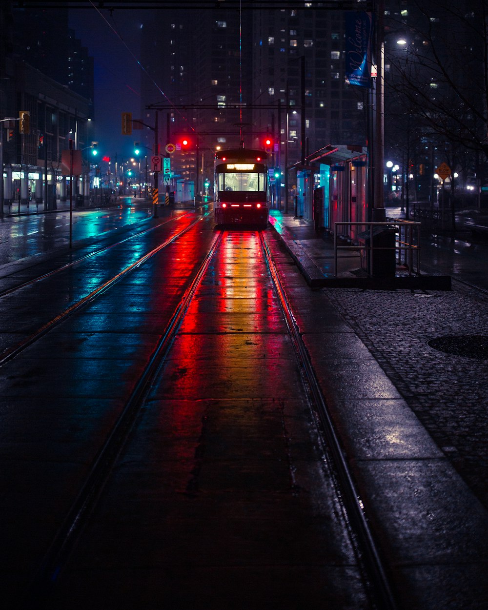 Photo d’un tramway à côté d’une station d’attente pendant la nuit