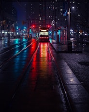 photo of tram beside waiting station during nighttime