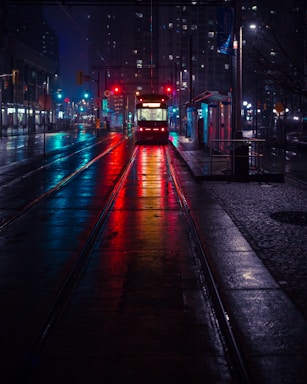 street photography,how to photograph red tram; photo of tram beside waiting station during nighttime