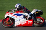person riding red and white sportbike